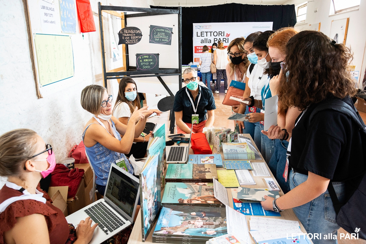 Banchetto di libri accessibili durante la fiera Lettori alla Pari